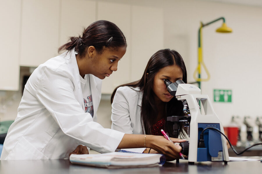 biology and health science students in a laboratory looking into a microscope