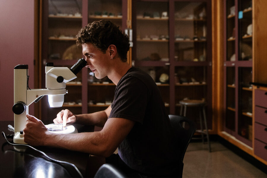 Biology student looks into a microscope.