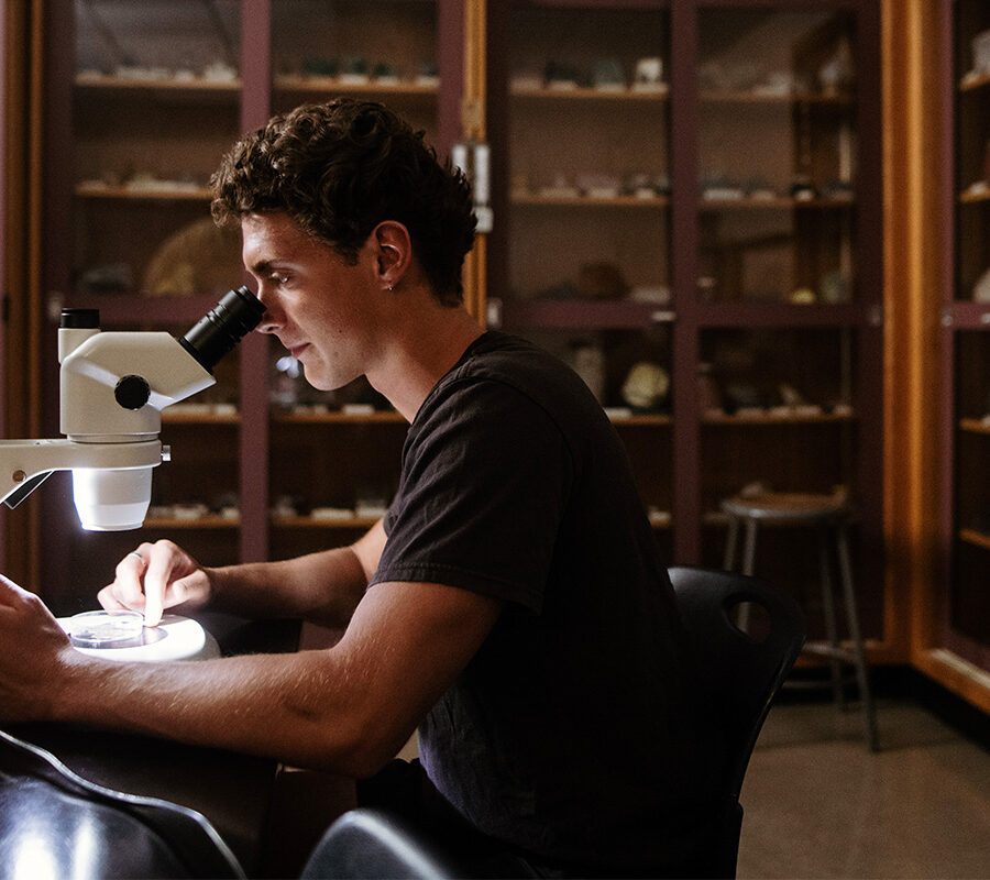 Biology student looks into a microscope.