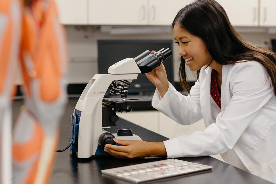 Student looks into a microscope in a laboratory session.