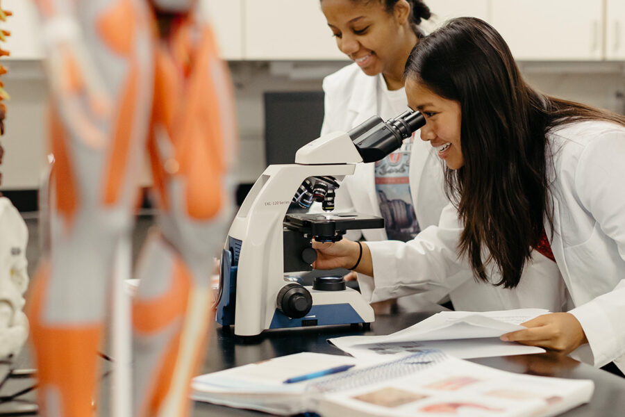 Student looks into a microscope in a laboratory session.