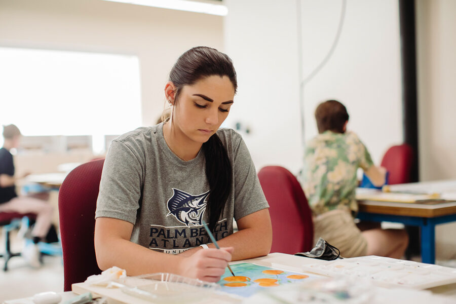 an art education student painting at a table