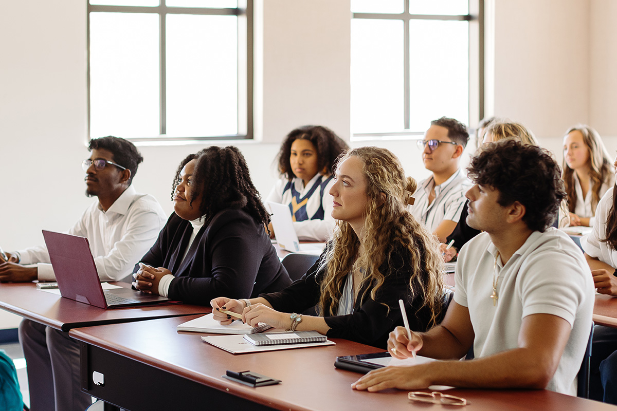 a group of students sitting in a classroom listening to a lecture