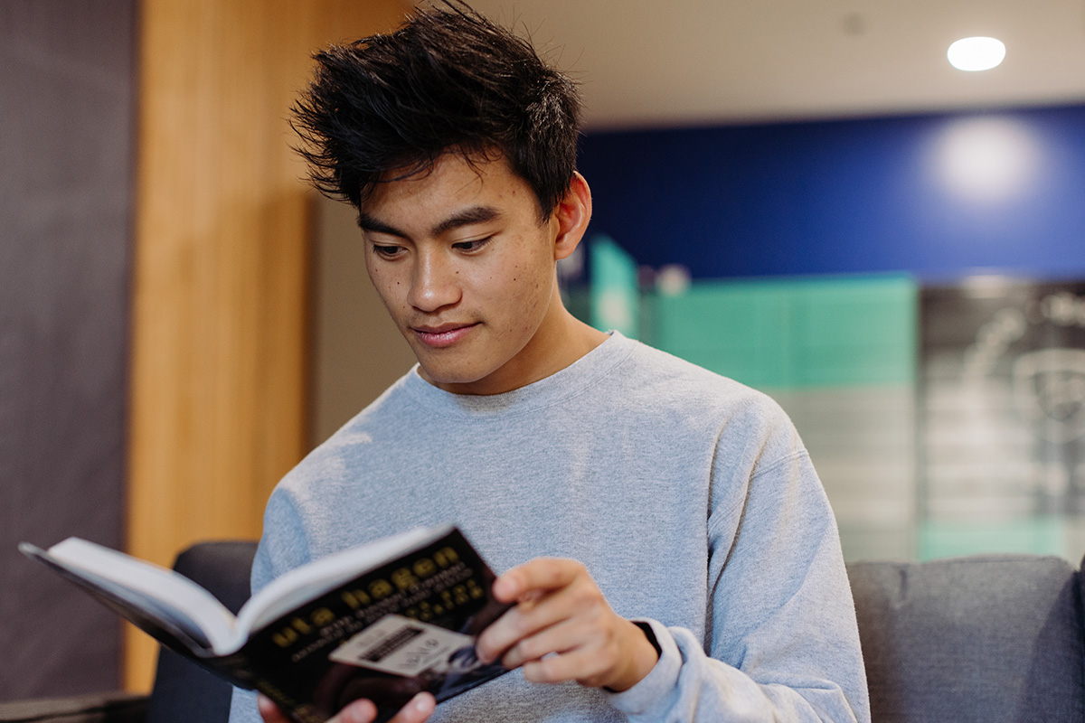 History student reads a book in the dorms.