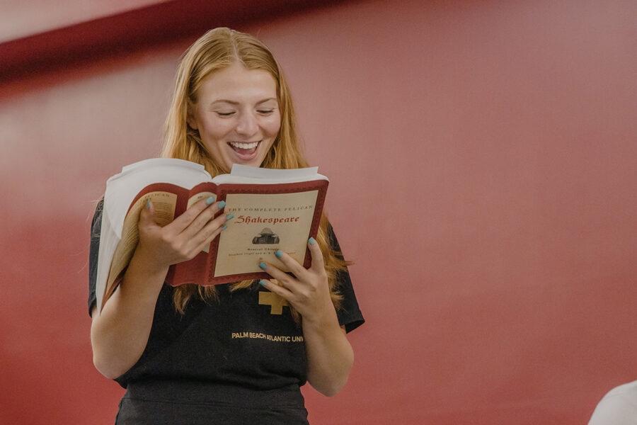 A student reading a book and smiling