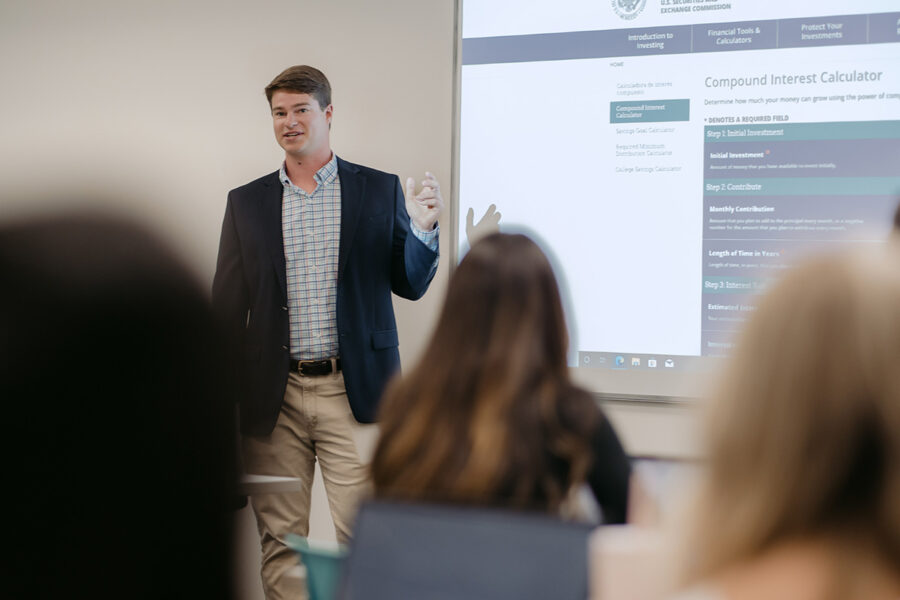 Student presents in front of a classroom.