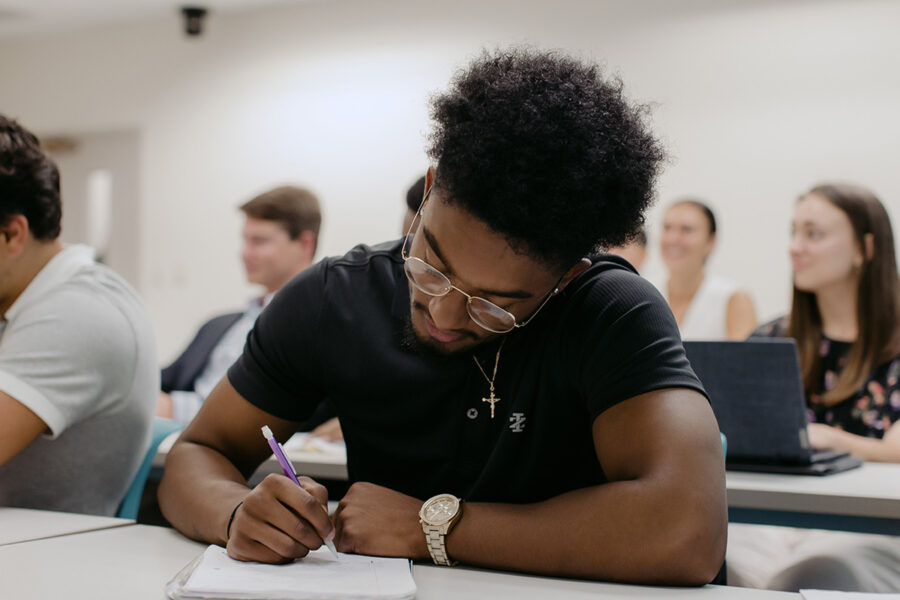 PBA student takes notes in class.