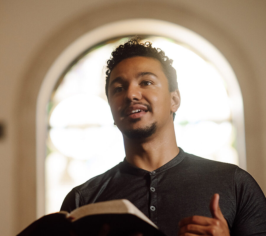 a PBA student holding a Bible while standing in the chapel
