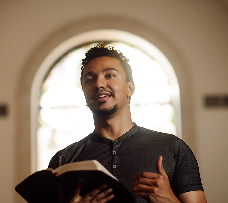 PBA student reads the bible at the front of chapel.