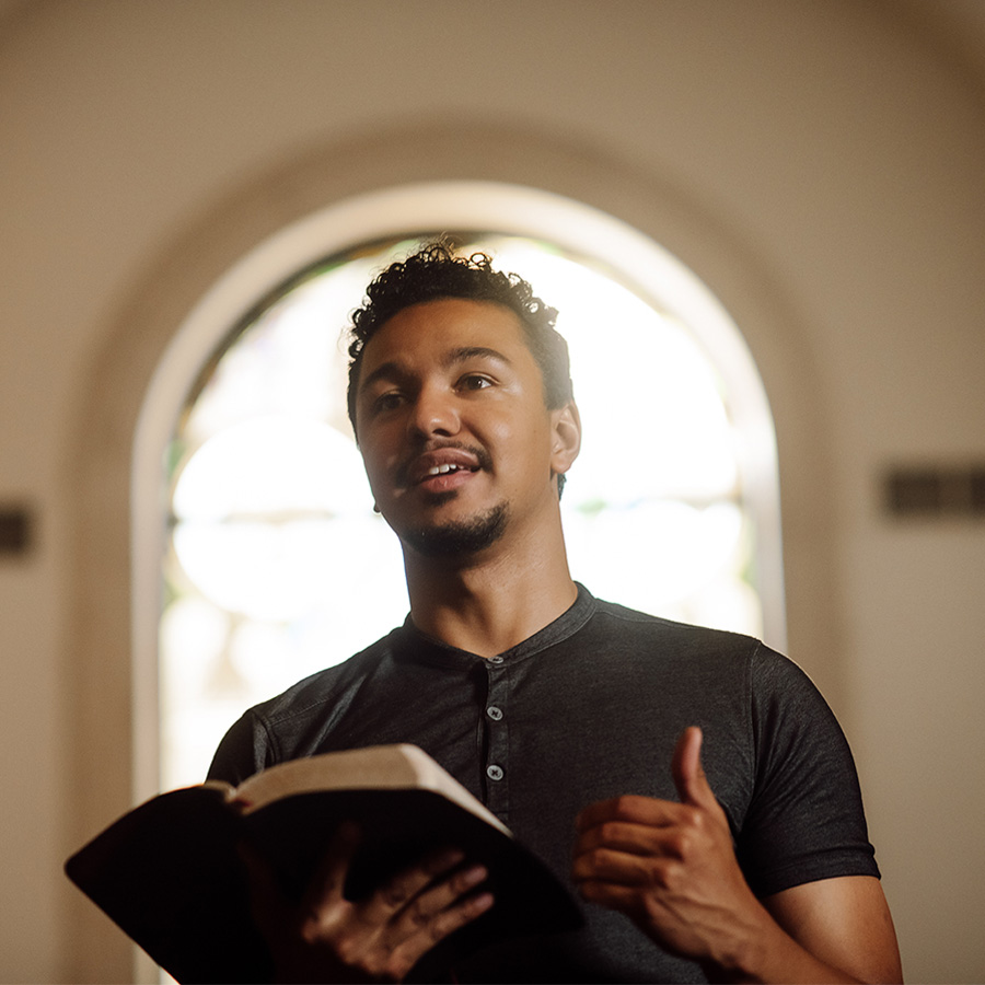 PBA student reads the bible at the front of chapel.
