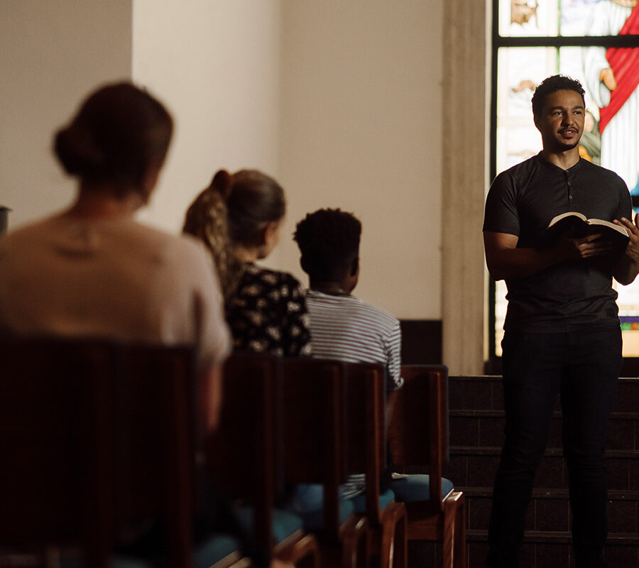 Student reads the bible at the front of chapel.