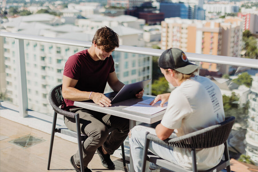 Two PBA students study on a rooftop.