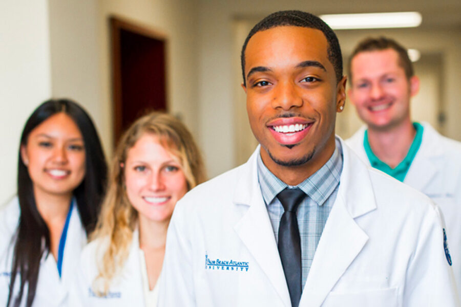 students from the doctor of pharmacy program standing in a hallway smiling