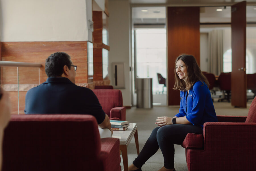 a student sitting in the library meeting with an admissions counselor