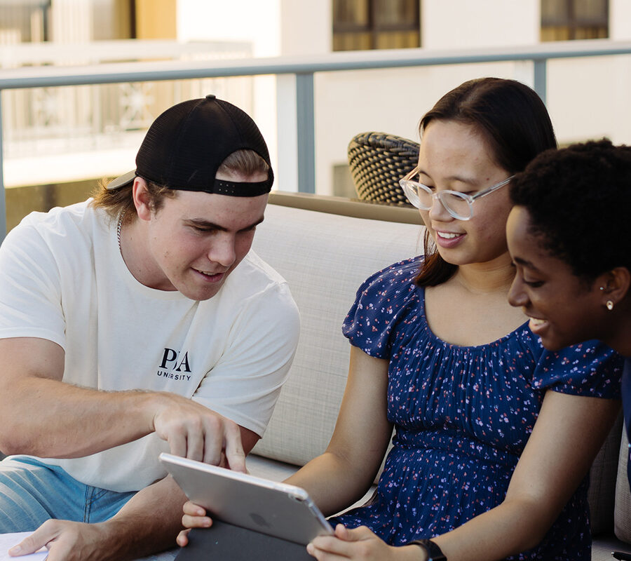 Students from the bachelor of general studies program study together on a balcony.