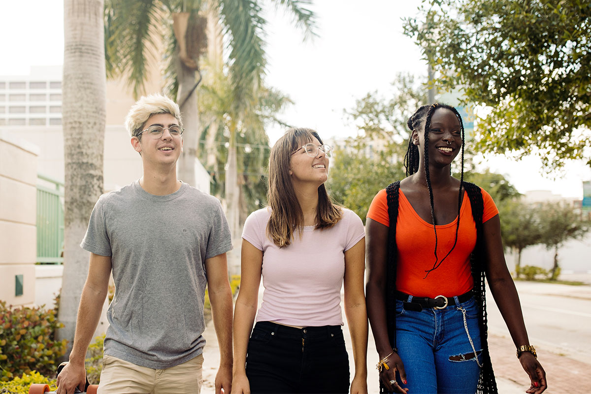 three PBA students program walk together on campus