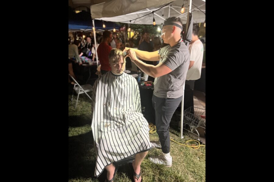 student getting a haircut at the 561 Night Market