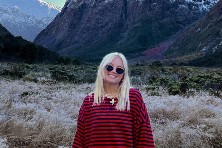 Reva Jenson poses in front of a mountain landscape.