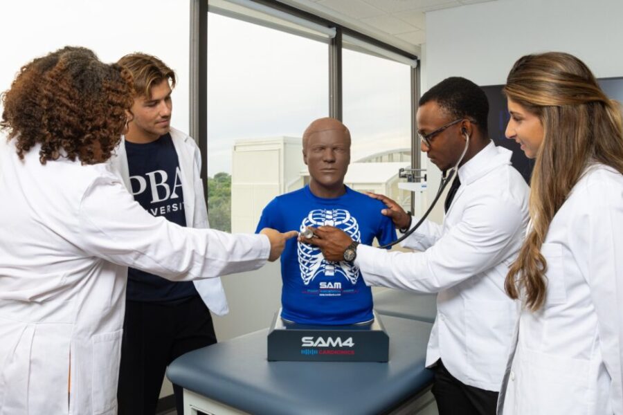 PBA instructor teaches new Physician Associate students how to conduct a medical examination on a bust.