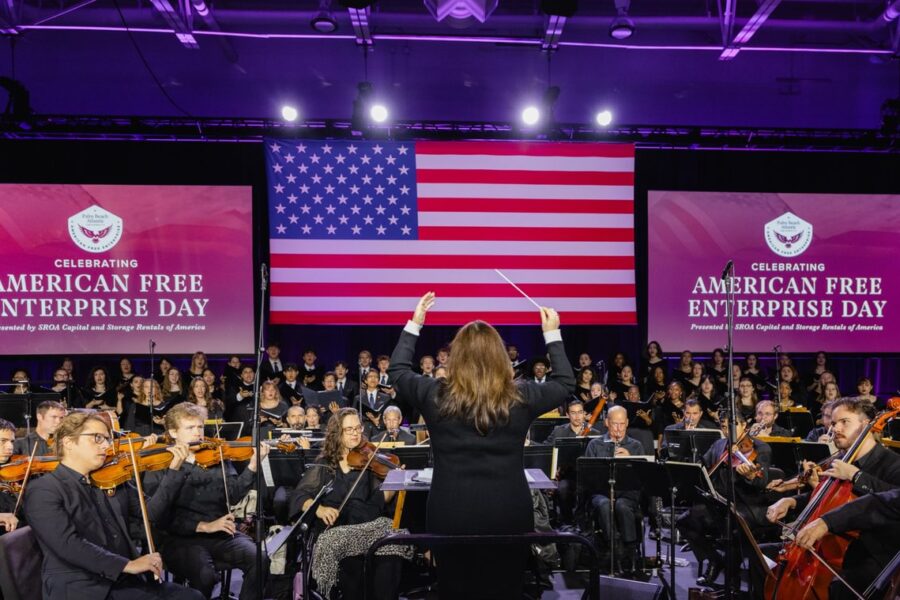 Directing the orchestra and choir on a patriotic stage.