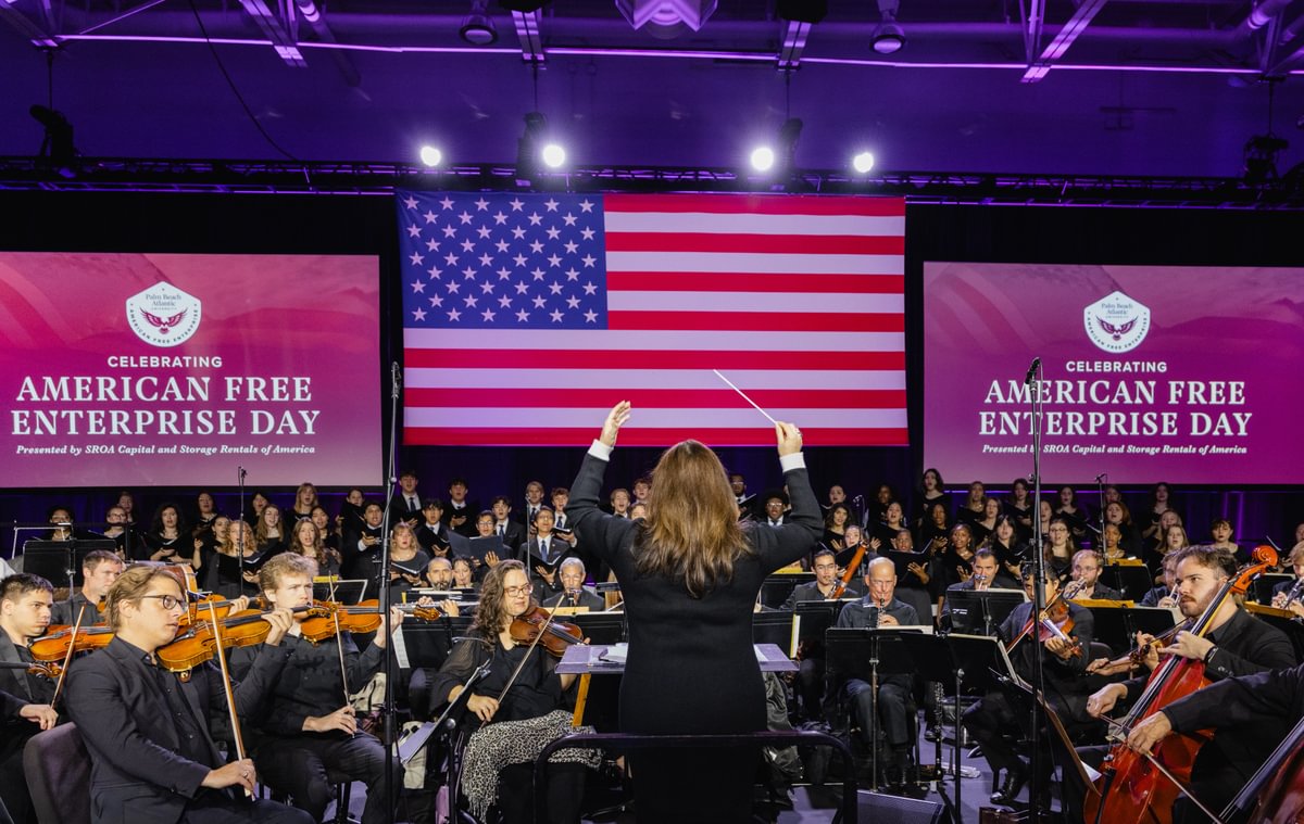 Directing the orchestra and choir on a patriotic stage.