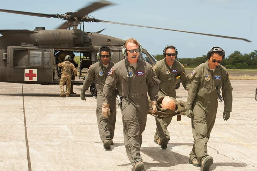 Luis Benitez carries a stretcher from a military helicopter with his team.