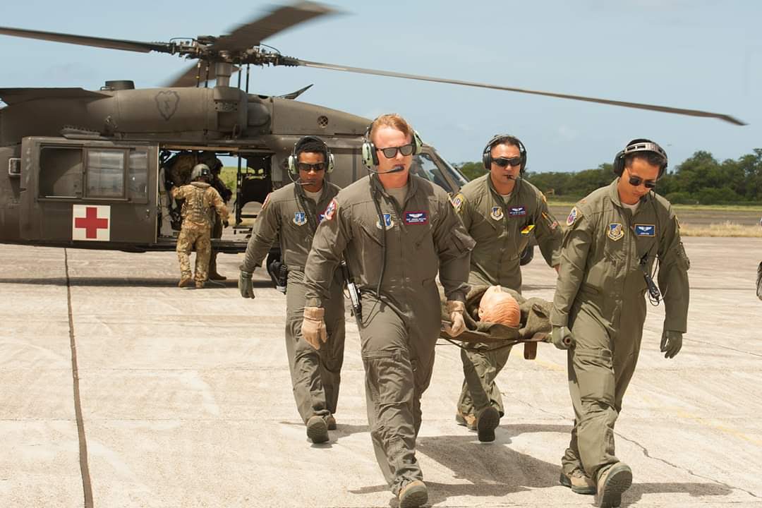 Luis Benitez carries a stretcher from a military helicopter with his team.