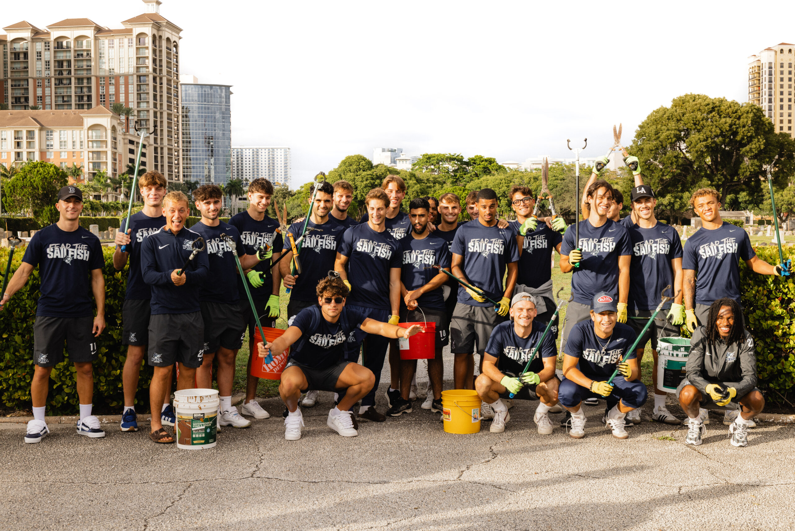Palm Beach Atlantic University's men's soccer team with equipment to volunteer with landscaping and picking up litter at a local graveyard.