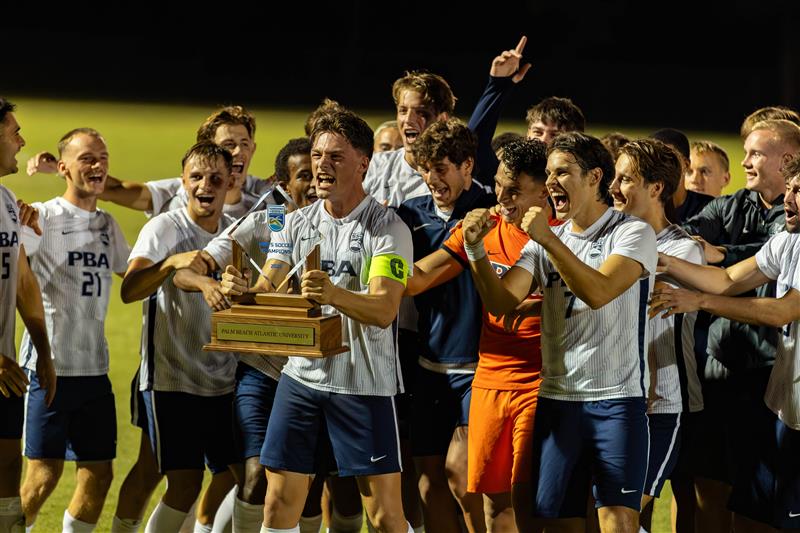 PBA's men's soccer team celebrate winning the Sunshine State Conference and trophy.