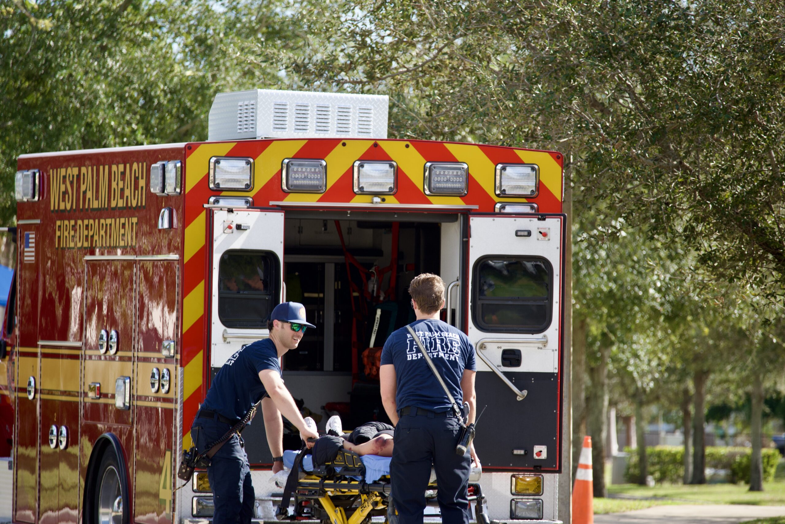 Local emergency responders practice transporting injured victims in disaster training simulation at Palm Beach Atlantic University.