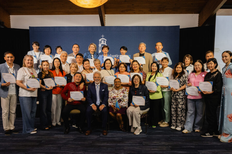 PBA Faculty members, Drs. Frank Marangos and Marcia Bedasse, sit surrounded by the attendees of the Kazakhstan Educators Conference.