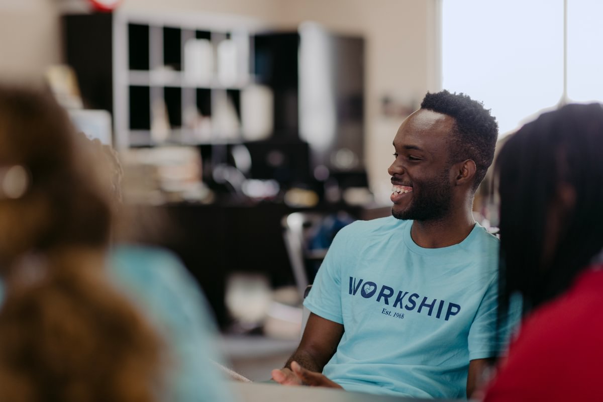 A Palm Beach Atlantic University student sports a blue Workship shirt while volunteering.