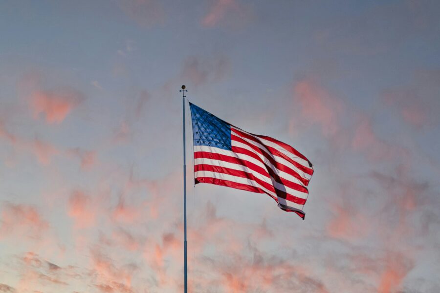 Dawn lights upon the American flag.
