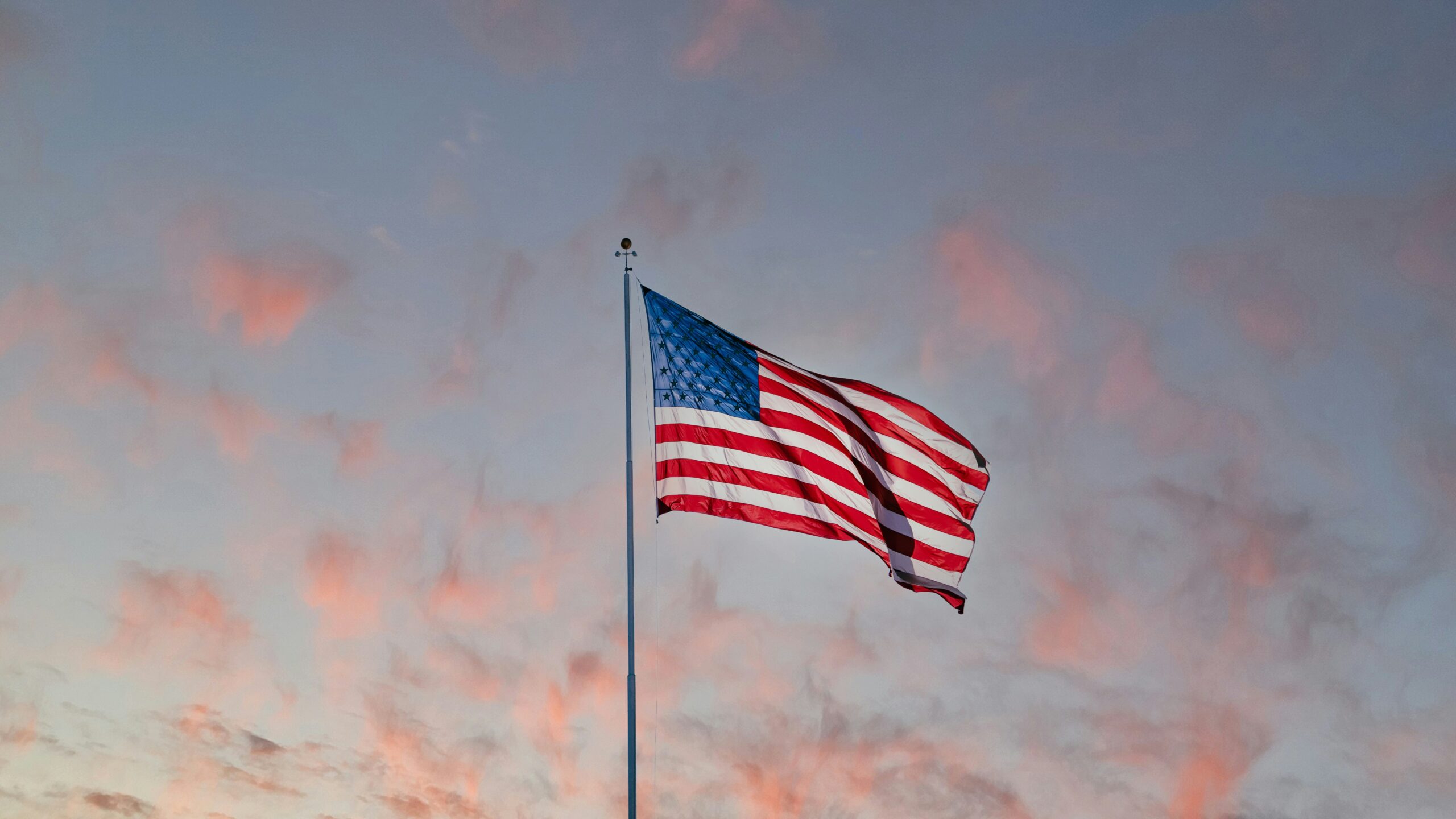 Dawn lights upon the American flag.