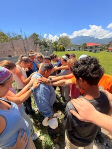 Palm Beach Atlantic University students pray for a local in Honduras.