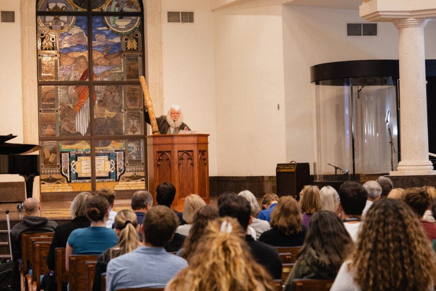 Malcolm Guite holds a rainstick while lecturing in Palm Beach Atlantic University's DeSantis Family Chapel.