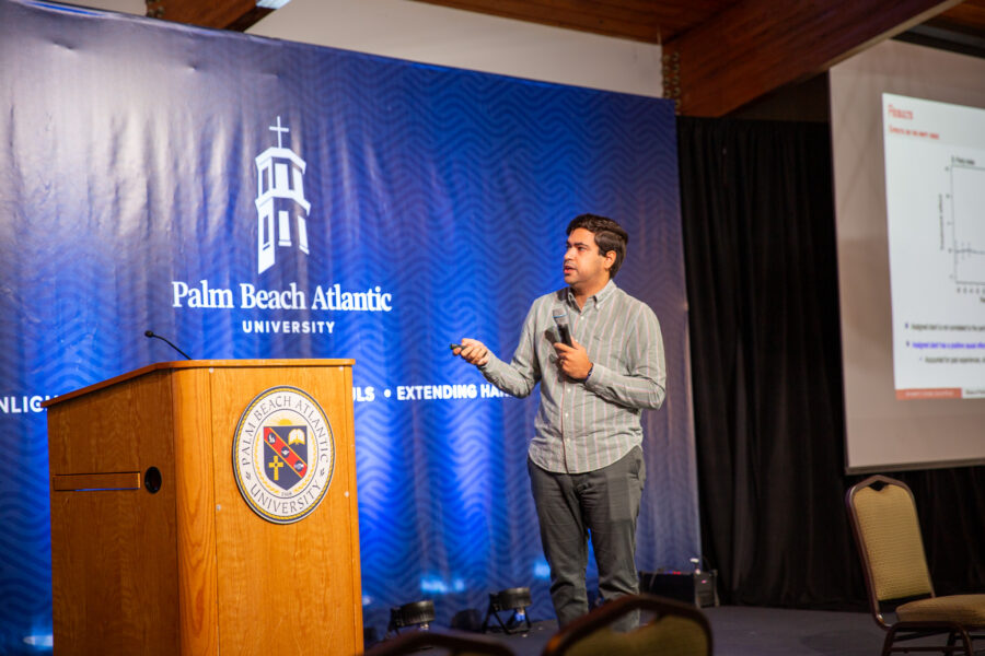 Man speaking in front of PBA logo