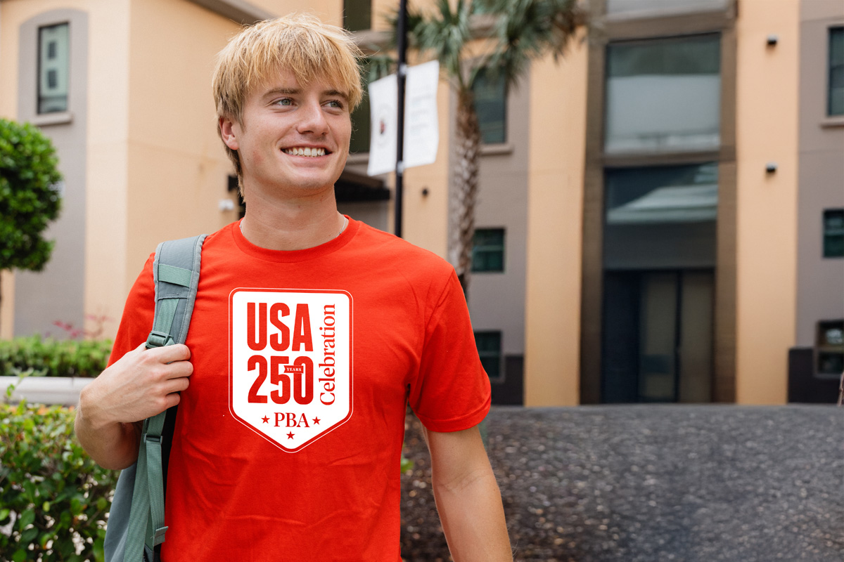 Palm Beach Atlantic University student displays PBA250 limited edition t-shirt, created to promote 250 acts of service in celebration of the nation's 250th anniversary.