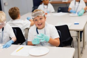 A student enthusiastically demonstrates a science experiment in a Palm Beach Atlantic University laboratory.