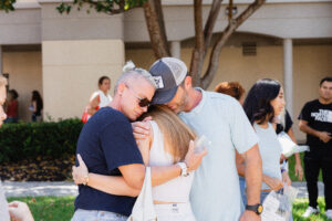 Mom and Dad hug daughter goodbye on PBA campus.